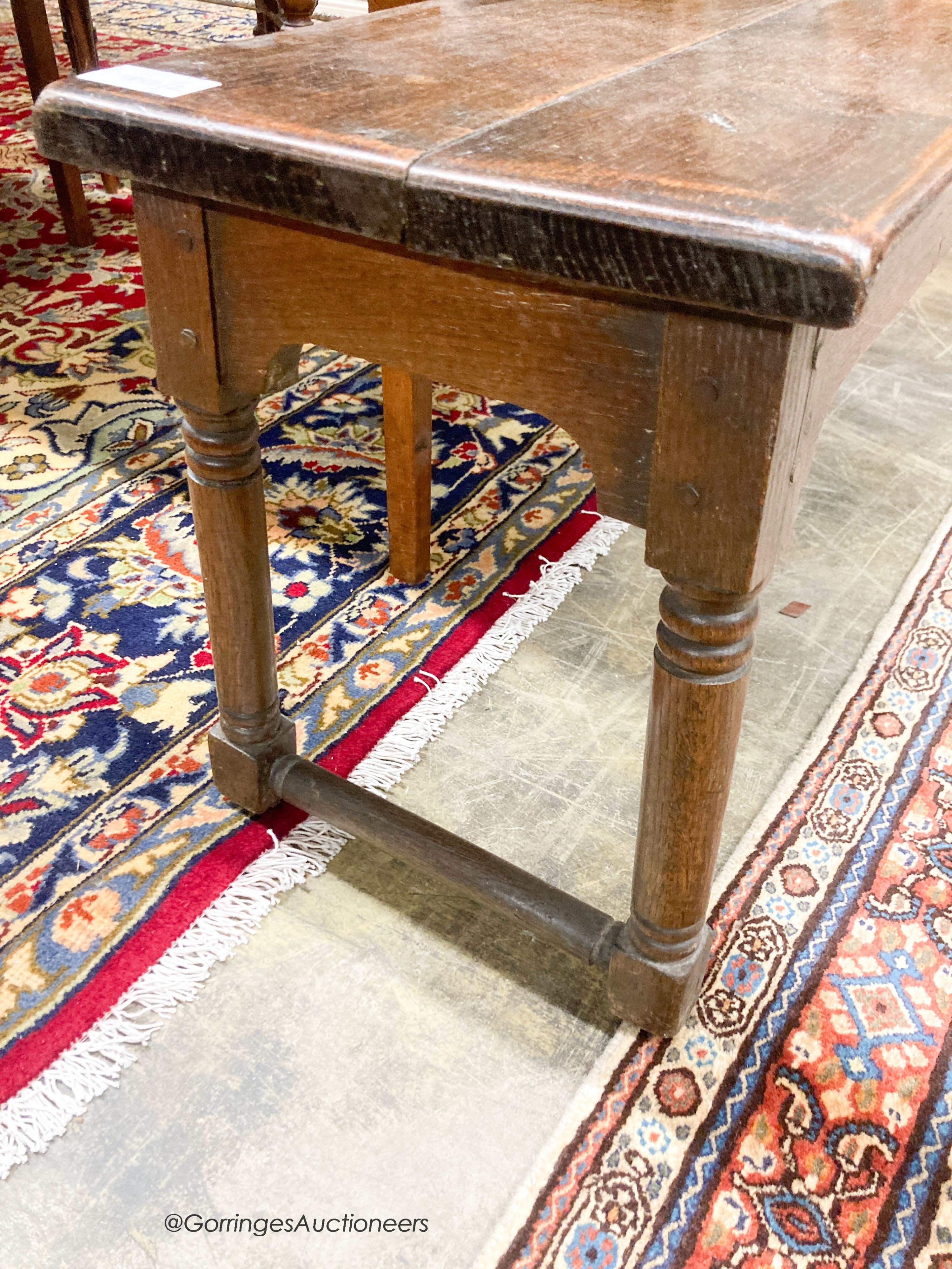 An 18th century style oak low bench seat, length 140cm, depth 32cm, height 42cm